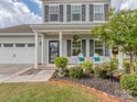 Close-up view of the charming front porch, featuring decorative chairs and manicured landscaping at 4205 Bent Green Ln, Monroe, NC 28112