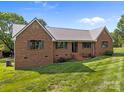 Well-maintained brick home featuring a durable metal roof, complemented by manicured landscaping for great curb appeal at 425 Troutman Rd, Rockwell, NC 28138