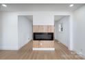 Bright living room featuring a fireplace and light wood flooring at 4500 Ridgeley Dr, Charlotte, NC 28208