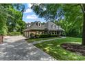 Beautiful brick home featuring an attached three-car garage, mature landscaping, and a welcoming front porch at 4920 Parview S Dr, Charlotte, NC 28226