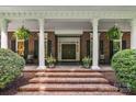 Inviting front porch with brick steps, white columns, and decorative plants, perfect for relaxing at 4920 Parview S Dr, Charlotte, NC 28226