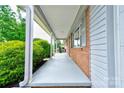 Covered front porch showing brick accents, white columns, and painted concrete at 504 Forest Ridge Dr, Shelby, NC 28152