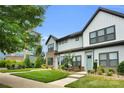 Two-story townhome boasting a manicured lawn, lush foliage, and inviting sidewalk access at 5946 Ardrey Kell Rd, Charlotte, NC 28277