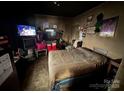 A bedroom with a bed, multiple TVs, and numerous wall decorations at 618 Douglas St, Shelby, NC 28150