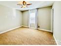 Spacious bedroom with plush carpet, a ceiling fan, and a large window with curtains at 664 Cape Fear St, Fort Mill, SC 29715