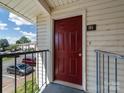 View of front door #91 with side railing, and parking lot visible to the left at 7977 Shady Oak Trl, Charlotte, NC 28210