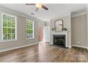 Cozy living room featuring a fireplace, wood floors, and plenty of natural light at 110 Dime Ln, Mooresville, NC 28117
