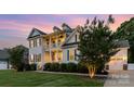 Elegant two-story home boasting a double porch, black shutters, and lush landscaping at 112 S Shore Dr, Belmont, NC 28012