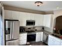 Bright kitchen featuring stainless steel appliances, granite countertops, stylish lighting, and ample white cabinetry at 1139 Drummond Ln, Matthews, NC 28104