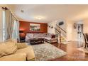 Comfortable living room featuring hardwood floors, a plush sectional sofa, and staircase at 117 Marakery Rd # B, Mooresville, NC 28115