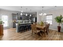 Open kitchen featuring gray cabinets, granite countertops, stainless appliances, a large island, and an adjacent dining area at 1177 Bannockburn Ave, Rock Hill, SC 29732