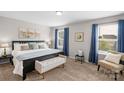 Bright main bedroom features ample natural light, carpet flooring, a decorative accent bench, and calming neutral tones at 1177 Bannockburn Ave, Rock Hill, SC 29732