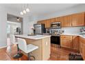 Lovely kitchen features an island with barstool seating, stainless steel appliances and wood flooring at 13838 Hill St, Huntersville, NC 28078