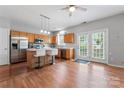 Kitchen with island seating, stainless appliances, and double doors leading to backyard at 13838 Hill St, Huntersville, NC 28078