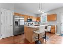 Lovely kitchen features an island with barstool seating, stainless steel appliances and wood flooring at 13838 Hill St, Huntersville, NC 28078