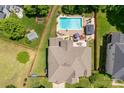 Stunning aerial view of a private backyard with a sparkling pool, patio, and lush greenery, all enclosed by a wooden fence at 143 Heywatchis Dr, Mooresville, NC 28115