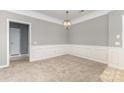 This dining room boasts decorative wall trim, a modern chandelier, and neutral walls at 14857 Santa Lucia Dr, Charlotte, NC 28277