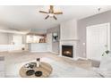 Bright living room features a fireplace, ceiling fan, and an open layout to the kitchen at 14857 Santa Lucia Dr, Charlotte, NC 28277