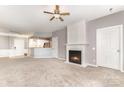 Carpeted living room featuring a fireplace, a ceiling fan, and view of the kitchen at 14857 Santa Lucia Dr, Charlotte, NC 28277