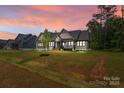 Picturesque home at dusk with manicured lawn, highlighting its inviting facade and neighborhood charm at 153 Mills Garden Rd, Statesville, NC 28625