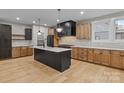 Modern kitchen with center island, sleek black appliances, light wood cabinets, and stylish pendant lighting at 153 Mills Garden Rd, Statesville, NC 28625