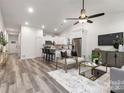 Sunlit open-concept living area with neutral color scheme and views into a white kitchen and stainless appliances at 1604 N Main St, Mount Holly, NC 28120