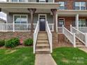 Close-up of a townhouse entrance with stone veneer, leading up to a black front door and porch at 2001 Laurel Village Cir, Belmont, NC 28012
