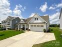 Traditional home with a two-car garage, covered porch, and manicured lawn in a quiet neighborhood at 2048 Turnsberry Dr, Monroe, NC 28112