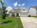 Charming exterior of a home with a well-manicured lawn, two-car garage, and inviting front porch at 2048 Turnsberry Dr, Monroe, NC 28112