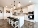 Modern kitchen featuring a large island with seating, stainless steel appliances, and stylish pendant lighting at 2048 Turnsberry Dr, Monroe, NC 28112