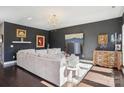 Stylish living room with dark walls, plush rug, elegant furniture, and hardwood flooring at 21610 Rio Oro Dr, Cornelius, NC 28031