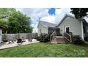 Private backyard with a patio, firepit area, lush lawn and mature trees provides a relaxing outdoor space at 303 N Main N St, Granite Quarry, NC 28146