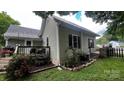 Home exterior with stone lined gardens and fenced backyard with deck at 303 N Main N St, Granite Quarry, NC 28146