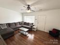Well-lit living room features a sectional sofa, modern coffee table, hardwood floors, and ample natural light at 3602 Melrose Cottage Dr, Matthews, NC 28105