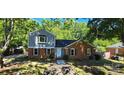 Charming two-story home with brick and gray siding surrounded by lush greenery at 401 Pamela St, Gastonia, NC 28054