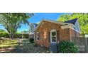 The side yard features brick exterior and lush greenery, complemented by mature trees at 401 Pamela St, Gastonia, NC 28054