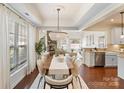 Elegant dining room boasts tray ceilings, wood floors, and a view into the living spaces at 4028 Woodsmill Rd, Fort Mill, SC 29707
