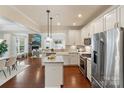 Modern kitchen with white cabinets, granite countertops, and stainless steel appliances overlooking the living room at 4028 Woodsmill Rd, Fort Mill, SC 29707