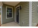 Home entry featuring black front door and light green vinyl siding at 407 Chambers St, Statesville, NC 28677