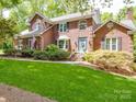 Charming two-story brick home with a well-manicured lawn and a welcoming blue front door at 5900 Colwick Nw Ct, Concord, NC 28027