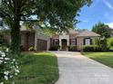 Charming brick home with a well-manicured lawn, mature trees, and a welcoming front entrance at 705 Woburn Abbey Dr, Fort Mill, SC 29715