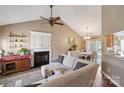 Cozy living room featuring a fireplace, a ceiling fan, and an open layout to the dining area at 8105 Castlemaine Dr, Matthews, NC 28104