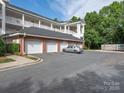 Four white garages beneath three-story condo building on a partly cloudy day at 8747 Coralbell Ln, Charlotte, NC 28213