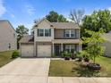 Charming two-story home with a well-manicured lawn, a two-car garage, and a welcoming front porch at 9132 Colwick Hill Ln, Charlotte, NC 28215