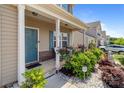 Charming front porch with a cozy seating area surrounded by beautiful landscaping and manicured flower beds at 9132 Colwick Hill Ln, Charlotte, NC 28215