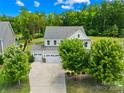 A stunning two-story home boasts a three-car garage, driveway and is surrounded by lush greenery at 10901 Greenvale Dr, Harrisburg, NC 28075