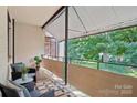 Relaxing covered balcony with outdoor seating and a view of the lush green trees in the neighborhood at 1121 Myrtle Ave # 72, Charlotte, NC 28203