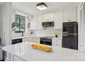 Bright kitchen featuring white cabinets, modern appliances, quartz countertops, and a black Galanz refrigerator at 1121 Myrtle Ave # 72, Charlotte, NC 28203