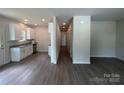 Open-concept kitchen with white cabinets, granite countertops, stainless appliances, and wood flooring at 1312 7Th St, Statesville, NC 28677