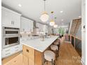Bright kitchen with white cabinets, marble countertops, and modern gold pendant lighting at 158 Mattoon St, Charlotte, NC 28216